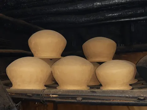 Earthen pots stored on a wooden shelf