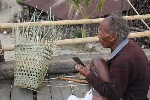 An elder weaving a bamboo basket