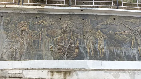Relief sculpture on a wall depicting village life